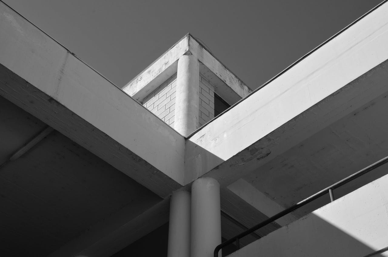 services-01 Minimalist black and white photo of a geometric architectural structure with concrete elements.